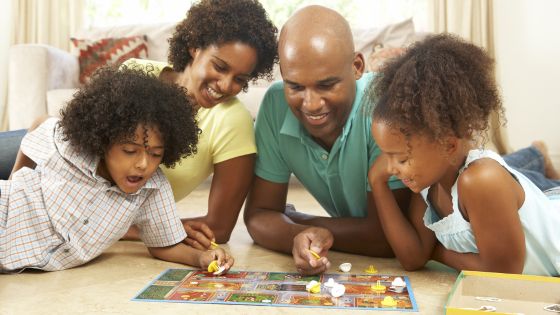 A family of four playing a board game together.