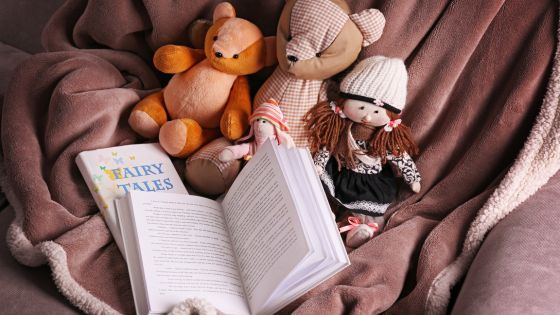 Picture of two fairy tale books, one closed and one open, with a range of fairy tale teddy characters such as teddy bears and dolls.