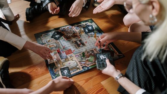 Family playing a board game together. It appears to be Cluedo.